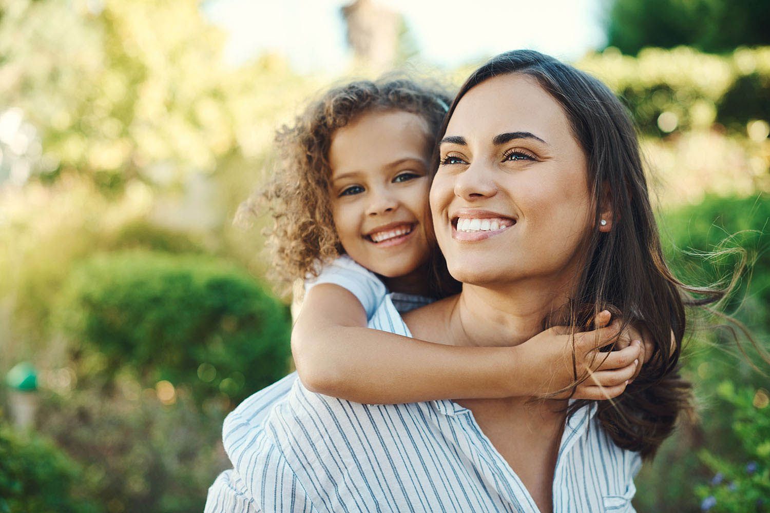 woman giving her daughter a piggyback ride