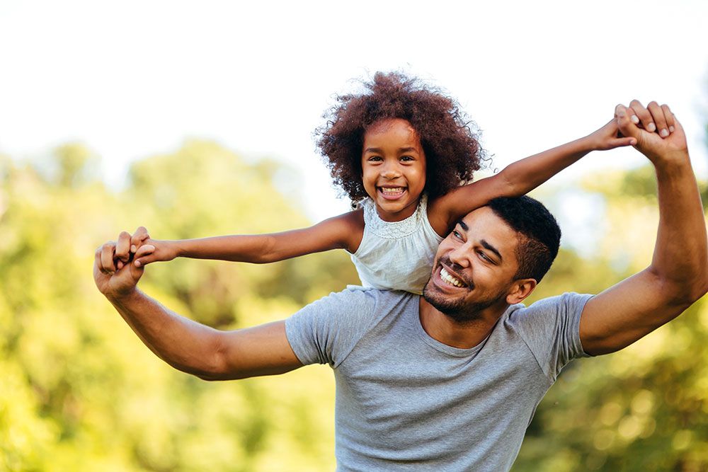 father with child on shoulders playing