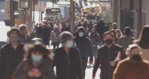 crowded street with people wearing masks