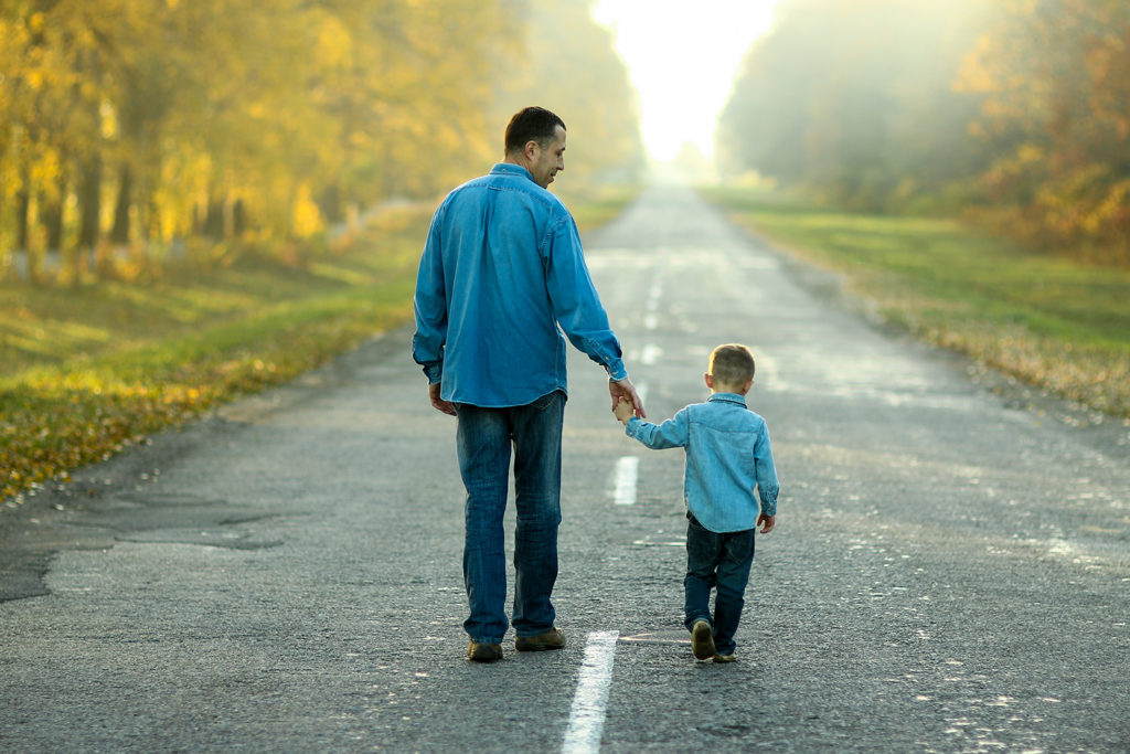 Father and Son Walking on Road