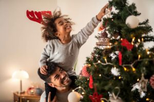 father decorating Christmas tree