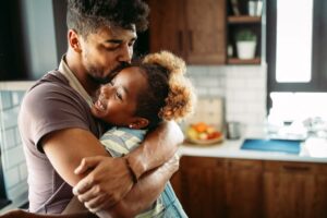 father hugging daughter in kitchen